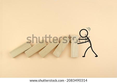 Falling wooden blocks, drawn by a person holding them. the concept of strength, leadership, resistance. Wooden cubes fall like dominoes, leaning on the wall, which is held by the drawn man.