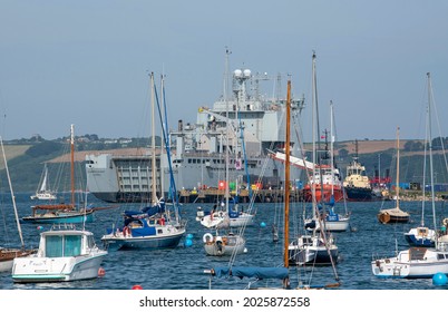 Falmouth, Cornwall, England, UK. 2021.  RFA vessel Cardigan Bay a Bay Class dock ship undergoing a refit in Falmouth Harbour surrounded by pleasure craft, cruisers, ferries and small boats.