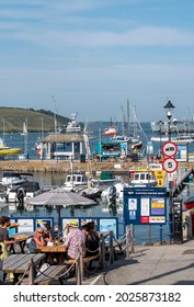 Falmouth, Cornwall, England, UK. 2021. Holidaymakers at a restaurant table being served traditional fish and chips. Falmouth harbour waterfront area.