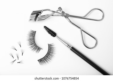 False eyelashes, brush and curler on white background