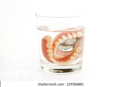 False Teeth Prosthetic In The Glass Of Water