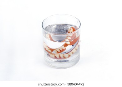 False Teeth Prosthetic In The Glass Of Water