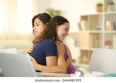 False woman hugging a cheated friend at home