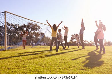 Families cheering scoring a goal during a football game