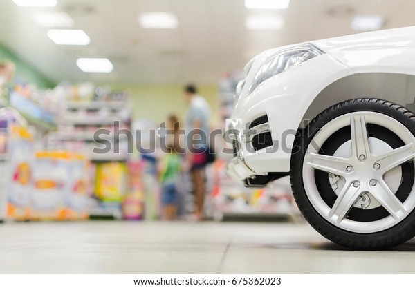 Families in the\
toy store, Mother\'s father and child look at the children\'s\
shop,toy closeup with blurred\
background