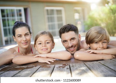 Family Of 4 Enjoying Bath In Spa Hot Tub