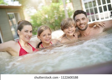 Family of 4 enjoying bath in spa hot tub