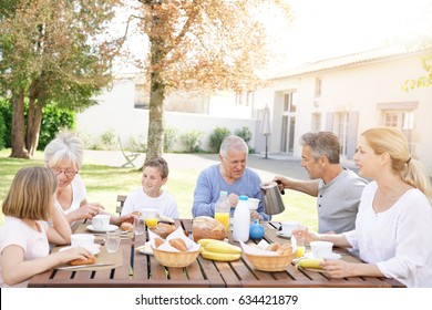 Family Of 6 Having Breakfast Together Outside The House