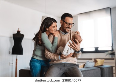 Family, adoption, baby, parenthood and people concept. Happy mother father with newborn baby at home - Powered by Shutterstock