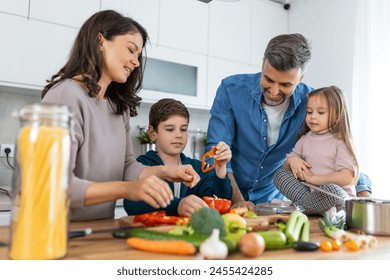 Family with adorable son and daughters gathered in modern kitchen cooking together. Enjoy communication and cookery hobby concept. - Powered by Shutterstock