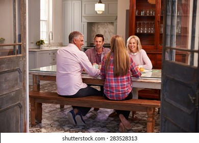 Family With Adult Offspring Enjoying Meal At Home Together