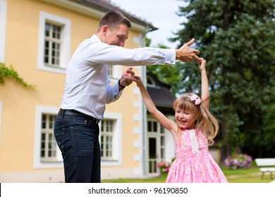 Family Affairs - Father And Daughter Playing In Summer; He Is Dancing With Her In The Garden In Front Of The House