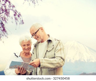 Family, Age, Tourism, Travel And People Concept - Senior Couple With Map And City Guide Over Japan Mountains Background