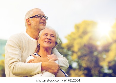 Family, Age, Tourism, Travel And People Concept - Senior Couple Hugging In Park