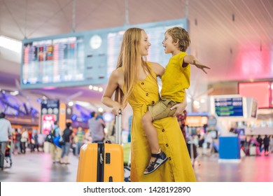 Family At Airport Before Flight. Mother And Son Waiting To Board At Departure Gate Of Modern International Terminal. Traveling And Flying With Children. Mom With Kid Boarding Airplane. Yellow Family