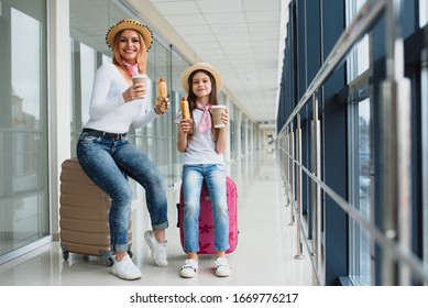 Family At Airport Before Flight. Mother And Kid Waiting To Board At Departure Gate Of Modern International Terminal. Traveling And Flying With Children. Mom With Baby At Boarding Airplane.