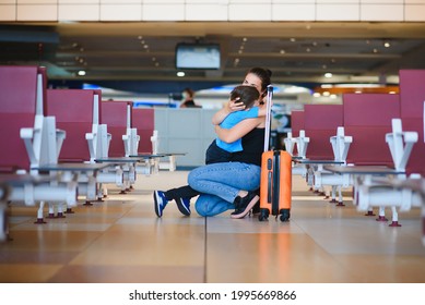 Family At Airport Before Flight. Mother And Son Waiting To Board At Departure Gate Of Modern International Terminal. Traveling And Flying With Children. Mom With Baby And Toddler Boarding Airplane.