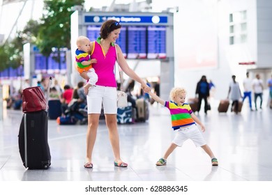 Family At Airport Before Flight. Mother And Kids Waiting To Board At Departure Gate Of Modern International Terminal. Traveling And Flying With Children. Mom With Baby And Toddler Boarding Airplane.