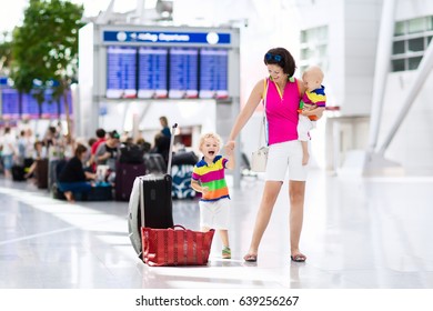 Family At Airport Before Flight. Mother And Kids Waiting To Board At Departure Gate Of Modern International Terminal. Traveling And Flying With Children. Mom With Baby And Toddler Boarding Airplane.