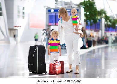 Family At Airport Before Flight. Mother And Kids Waiting To Board At Departure Gate Of Modern International Terminal. Traveling And Flying With Children. Mom With Baby And Toddler Boarding Airplane.