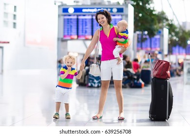 Family At Airport Before Flight. Mother And Kids Waiting To Board At Departure Gate Of Modern International Terminal. Traveling And Flying With Children. Mom With Baby And Toddler Boarding Airplane.