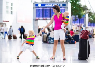 Family At Airport Before Flight. Mother And Kids Waiting To Board At Departure Gate Of Modern International Terminal. Traveling And Flying With Children. Mom With Baby And Toddler Boarding Airplane.