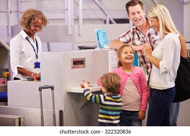 Family At Airport Check In Desk Leaving On Vacation