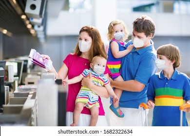 Family in airport in face mask. Virus outbreak. Coronavirus and flu pandemic. Safe travel with young child and baby. Mother, father and kids boarding airplane in surgical masks.