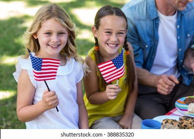 Family with American flag having a picnic in a park - Powered by Shutterstock