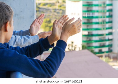 Family Applauding Medical Staff From Their Balcony. People In Spain Clapping On Balconies And Windows In Support Of Health Workers During The Coronavirus Pandemic