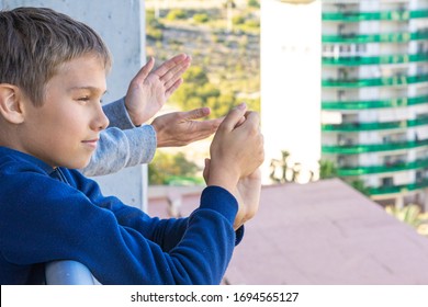 Family Applauding Medical Staff From Their Balcony. People In Spain Clapping On Balconies And Windows In Support Of Health Workers During The Coronavirus Pandemic