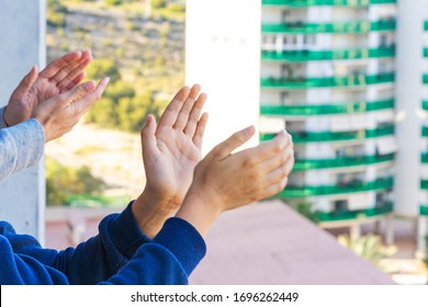 Family Applauding Medical Staff From Their Balcony. People In Spain Clapping On Balconies And Windows In Support Of Health Workers During The Coronavirus Pandemic