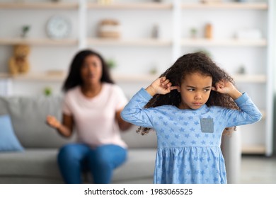 Family argument. Sad offended black girl covering ears, not wanting to listen to her mother's scloding, free space. Millennial woman having fight with her child, quarelling at home - Powered by Shutterstock