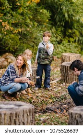 Family Around A Campfire In Fall/autumn Day.