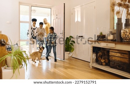 Family arriving home, boy with Down syndrome with dog