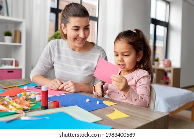 Family, Art And Craft Concept - Mother Spending Time With Her Little Daughter With Glue Making Applique Of Color Paper At Home