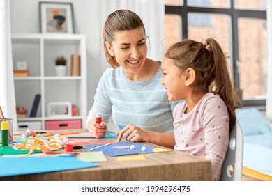 Family, Art And Craft Concept - Mother Spending Time With Her Little Daughter With Glue Making Applique Of Color Paper At Home