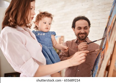 Family of artists working in art studio painting picture on easel together with little girl - Shutterstock ID 655689214
