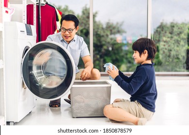 Family Asian Father And Kid Little Boy Son Having Fun Doing Household Chores Doing Laundry Dirty Clothes Into The Washing Machine Together In Laundry Room At Home