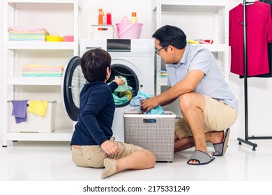 Family Asian Father And Kid Little Boy Son Having Fun Doing Household Chores Doing Laundry Dirty Clothes Into The Washing Machine Together In Laundry Room At Home