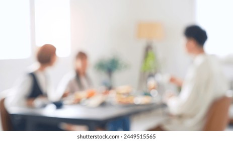 A family of an Asian girl and her parents sit around the dining table and enjoy a meal. Blurred concept. - Powered by Shutterstock