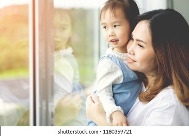 Family Asian Mother And Child Daughter Look Out The Window On A Autumn Day