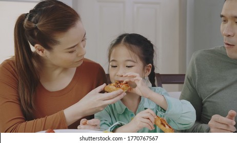 Family Asian People Are Happy To Eat Enjoy Tasty Pizza At Home. Parents And Daughter Eating Delicious Italian Food From Takeaway Delivery. Concept Food Takeout