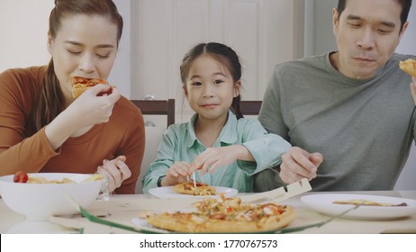 Family Asian People Are Happy To Eat Enjoy Tasty Pizza At Home. Parents And Daughter Eating Delicious Italian Food From Takeaway Delivery. Concept Food Takeout