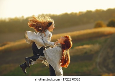 Family In A Autumn Field. Mother With Red Hair. Cute Little Girl