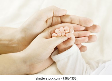 Hands für Kinder. Vater und Mutter, die das neugeborene Kind hält. KinderHand, Nahaufnahme zu Eltern