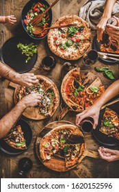 Family With Baby Having Pizza Party Dinner. Flat-lay Of People Eating Italian Pizza And Drinking Red Wine From Glasses Over Wooden Table, Top View. Fast Food Lunch, Gathering, Celebration