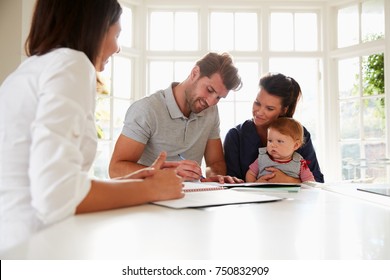 Family With Baby Meeting Financial Advisor At Home