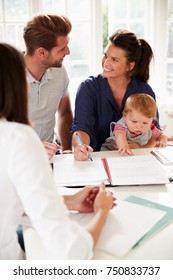 Family With Baby Meeting Financial Advisor At Home