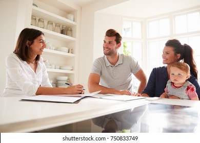 Family With Baby Meeting Financial Advisor At Home